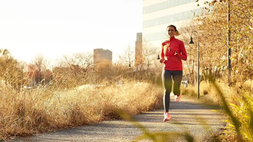 Joggerin im herbstlichen Sonnenlicht